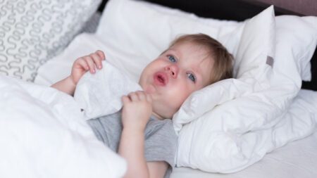 Kind liegt krank im Bett