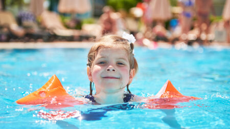 Mädchen mit Schwimmflügel in einem Schwimmbecken