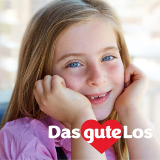 Kind mit langen Haaren stützt Kopf auf Hände vor unscharfem Hintergrund mit Text 'Das gute Los' und rotem Herzsymbol
