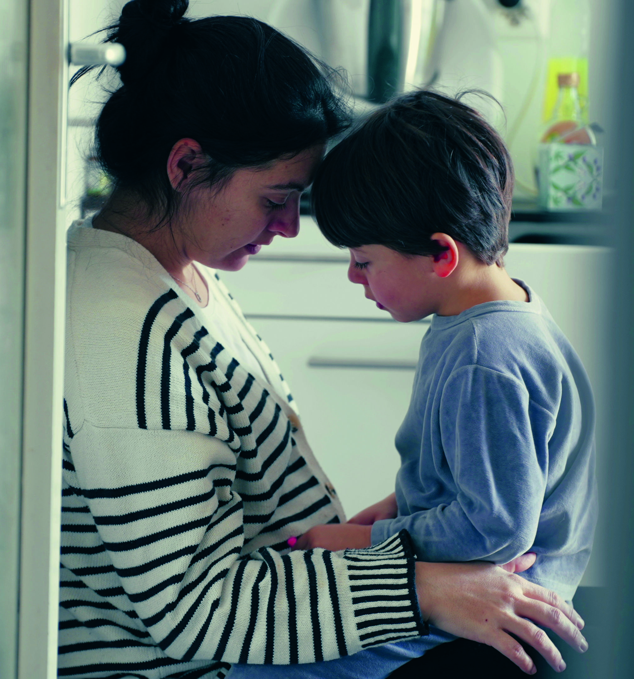 Mutter und Sohn halten die Köpfe aneinander