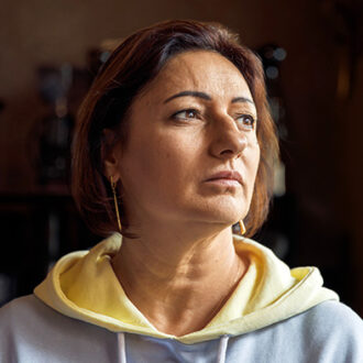 Porträt einer Frau in ihrer Wohnung – viele Menschen sind auf Sozialhilfe angewiesen.