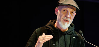 Erich Fenninger spricht an einem Rednerpult und gestikuliert mit der Hand