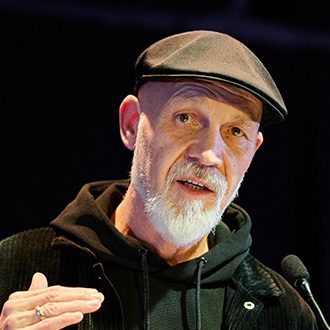 Erich Fenninger spricht an einem Rednerpult und gestikuliert mit der Hand