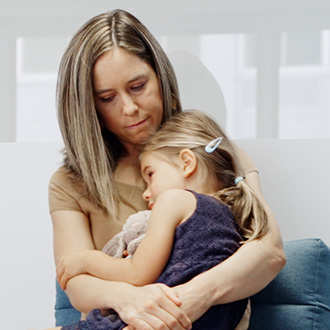 Eine Frau hält ein Kind auf dem Schoß.