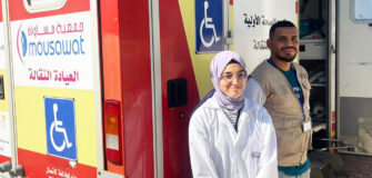 Mitarbeiterin und Mitarbeiter stehen vor der mobilen Klinik im Libanon.