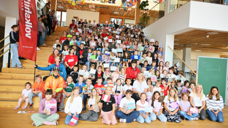 Hunderte Schüler*innen der Volksschule Magdalensberg singen ein eigens komponiertes Lied gegen Kinderarmut beim Tour-de-Chance-Stopp in Kärnten.