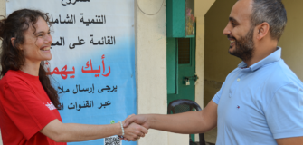 Eine Mitarbeiterin der Volkshilfe begrüßt einen Mitarbeiter der Partnerorganisation Mousawat vor einem Projektstandort im Libanon.