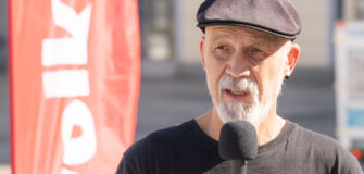 Erich Fenninger spricht bei einer Kundgebung für die Sozialhilfe in Linz im Oktober 2026 ins Mikrofon.