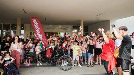 Schüler*innen und Radfahrer*innen der Tour de Chance 2025 vor dem Schulcampus Güssing.