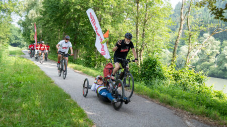 Svetlana Moshkovich im Handbike und Erich Fenninger mit weiteren Radfahrer*innen bei der Tour de Chance 2025 in Kärnten.