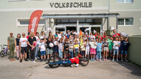 Schüler*innen, Lehrpersonen und Tour-de-Chance-Team vor der Volksschule Paternion.
