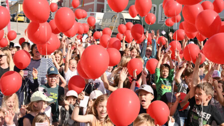 Schulkinder mit roten Luftballons beim Start der Tour de Chance 2025 in Bad Zell.